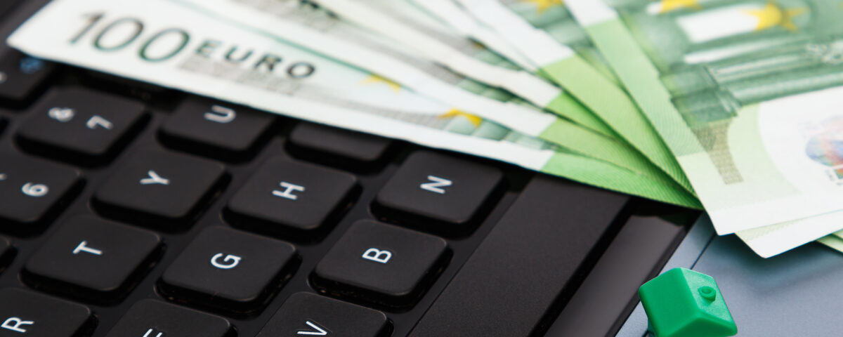 House and euro banknotes over laptop keyboard