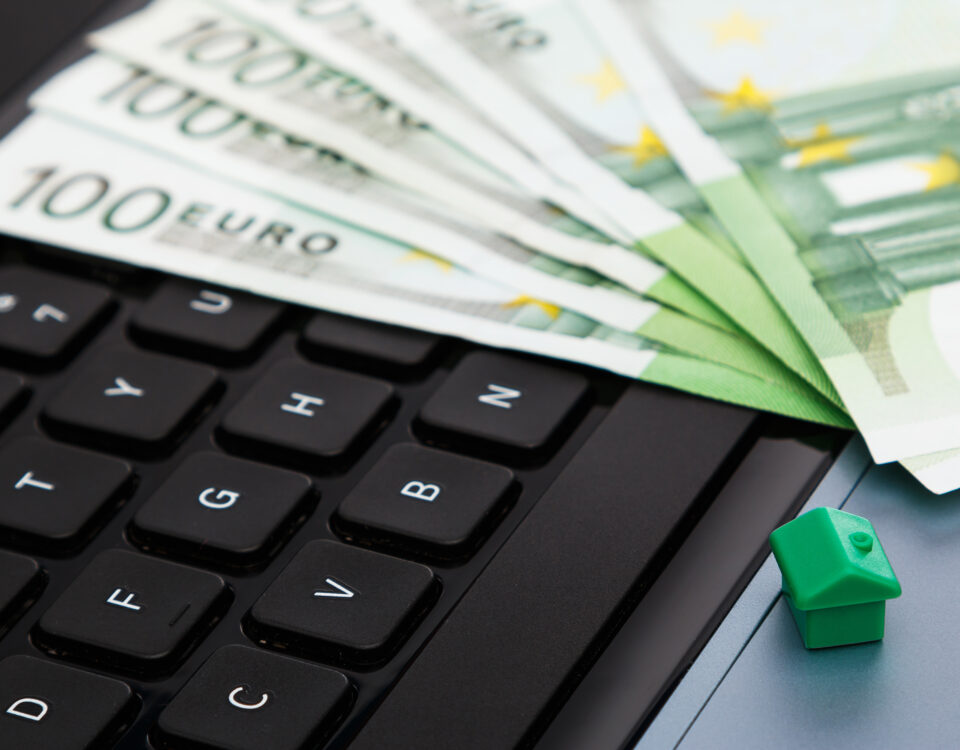 House and euro banknotes over laptop keyboard